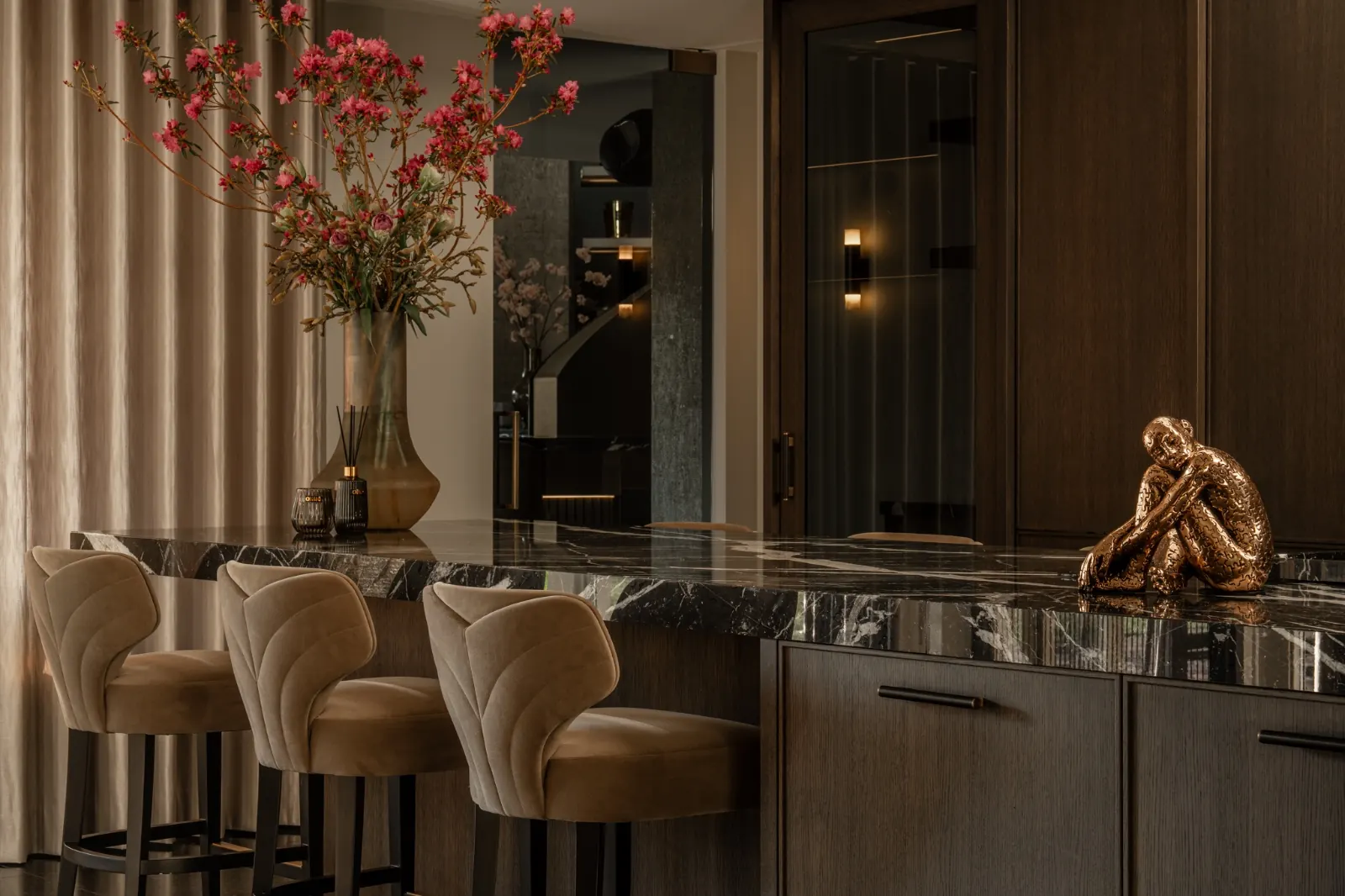 Donkere maatwerkkeuken met natuurstenen eiland en bloemen