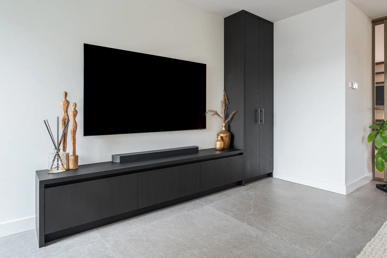 Donker tv-meubel op maat in een lichte woonkamer