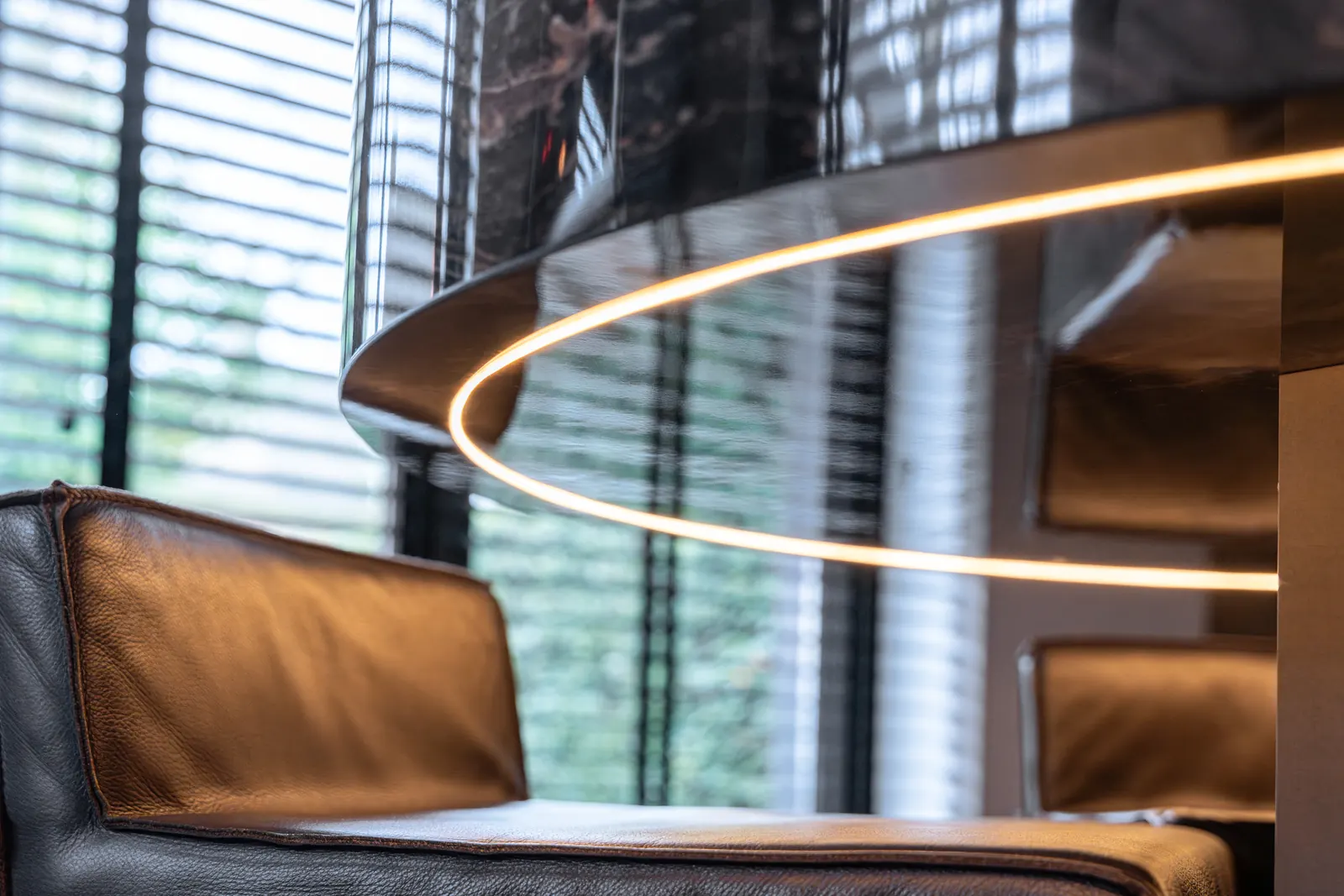 Hanglamp en fauteuil naast een houten maatwerkmeubel