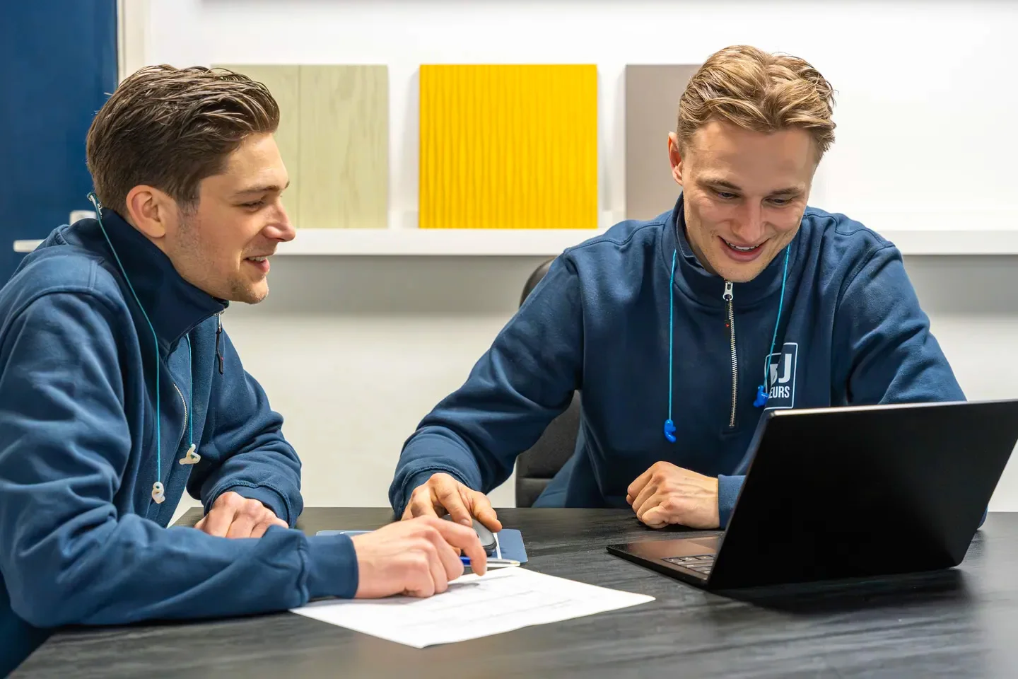 Kevin en Mika bespreken samen een interieurontwerp aan tafel